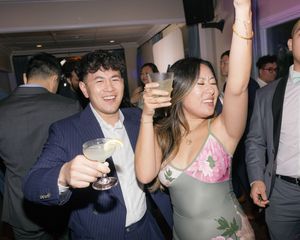 People enjoying drinks and dancing at what appears to be a social gathering or party event.