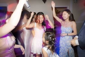 People enjoying themselves while dancing at a nightclub with colorful lights and party atmosphere.