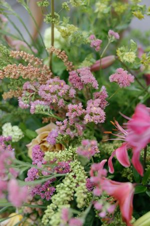 Close-up shots of pink and green floral arrangements featuring delicate astilbe flowers and natural foliage.