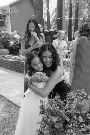 A touching black and white series of candid embraces and shared moments between parent and child in a garden setting.