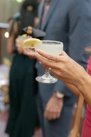 Various close-up shots of hands holding champagne or cocktail glasses at an elegant event.