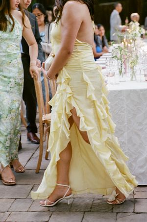 A flowing pale yellow bridesmaid dress with ruffled layers is captured in multiple close-up shots showing graceful movement.