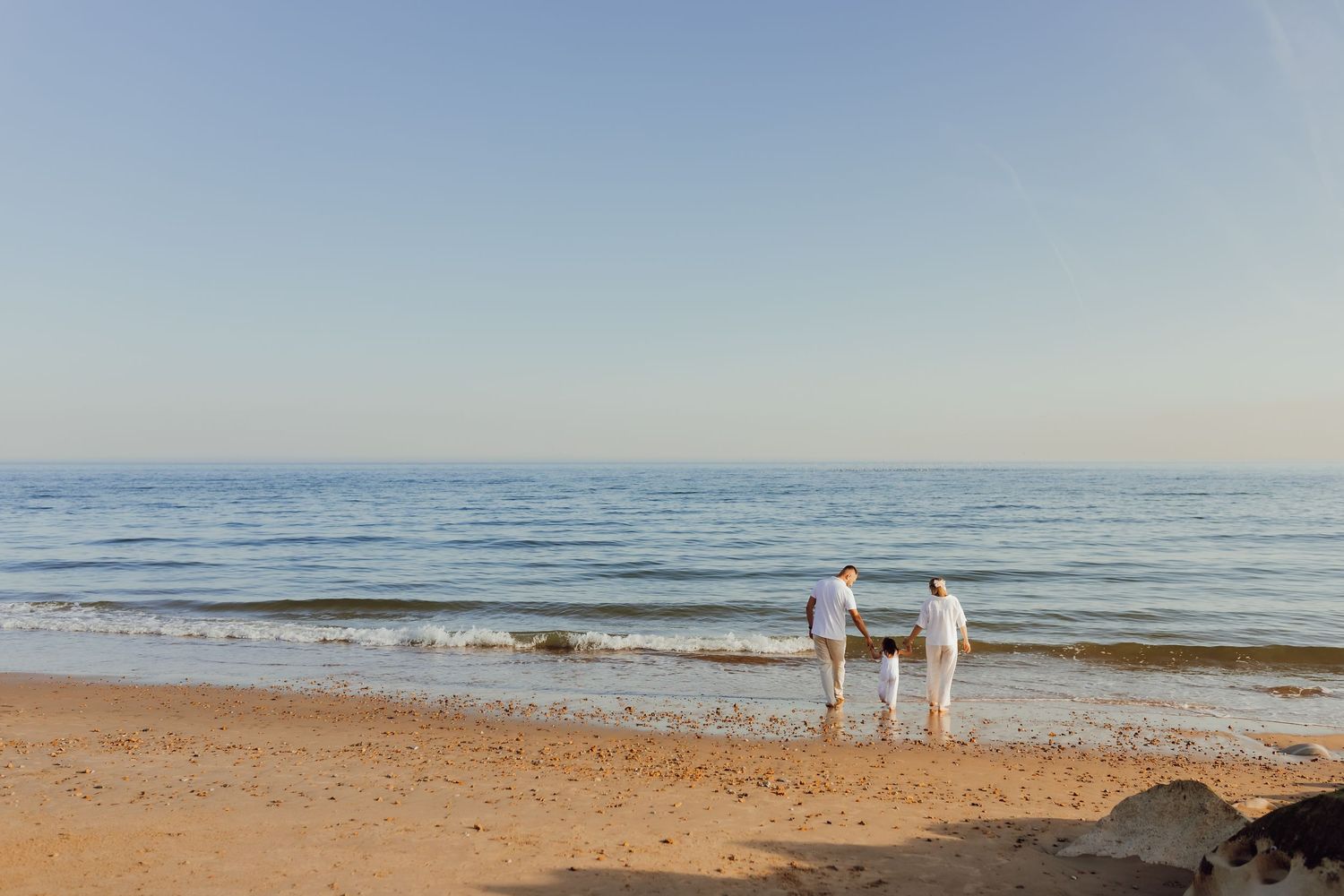 Family walking along Bournemouth beach before sunset, natural and relaxed family photography