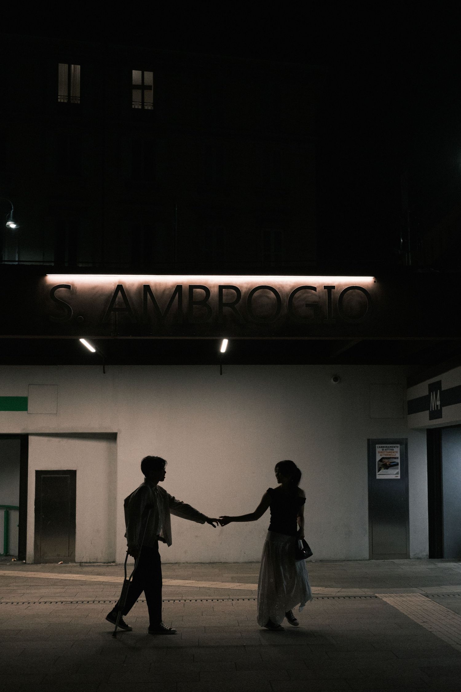 Silhouette couple walking Milan night streets Duomo