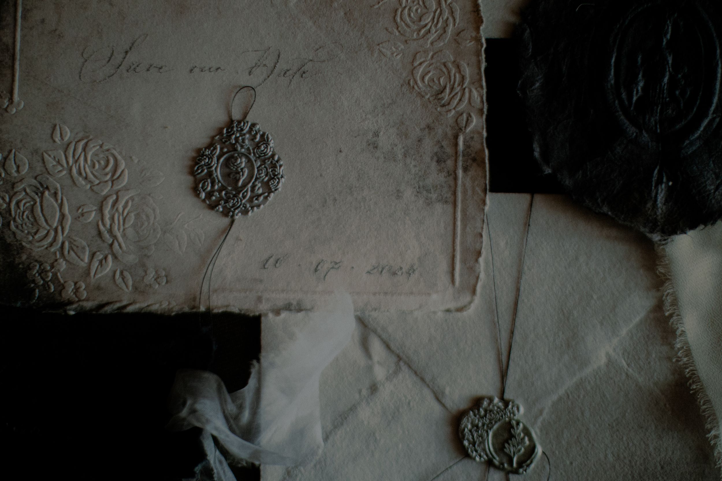Vintage letters with ornate wax seals and embossed details on aged paper in moody lighting.