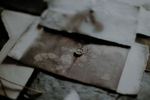 A collection of vintage photographs and documents scattered across a wooden surface creating a nostalgic display.