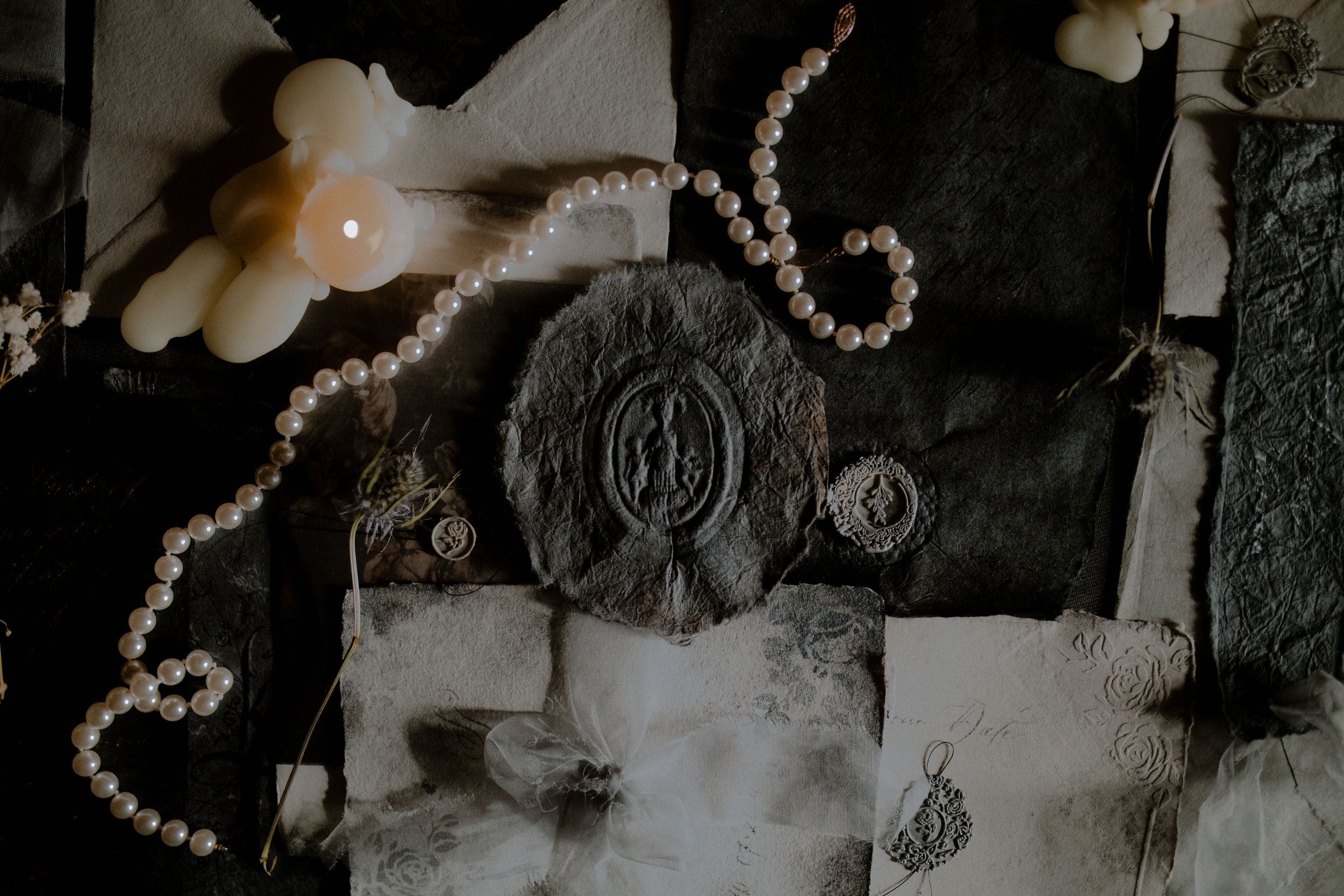 A vintage-style black and white photo collage featuring flowers, pearls, and decorative elements in a romantic arrangement.