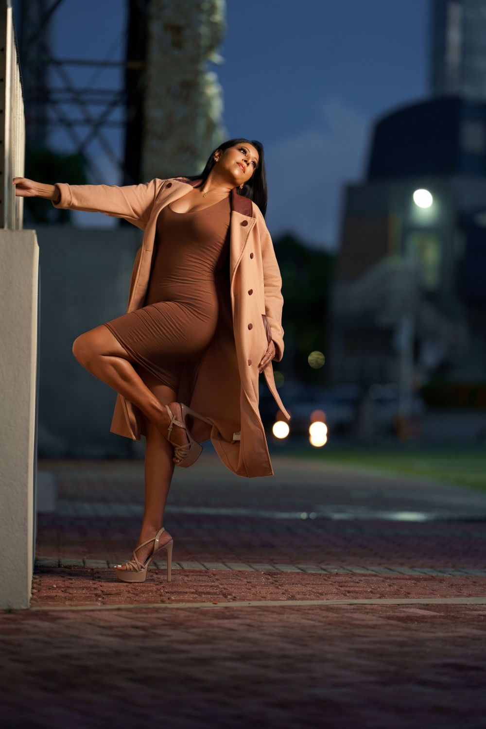 Artistic evening photoshoot featuring earth-toned clothing and dramatic poses against white columns.