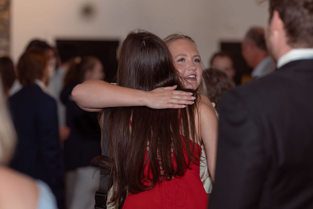 People dancing and socializing at an elegant evening event with formal attire and a lively atmosphere.