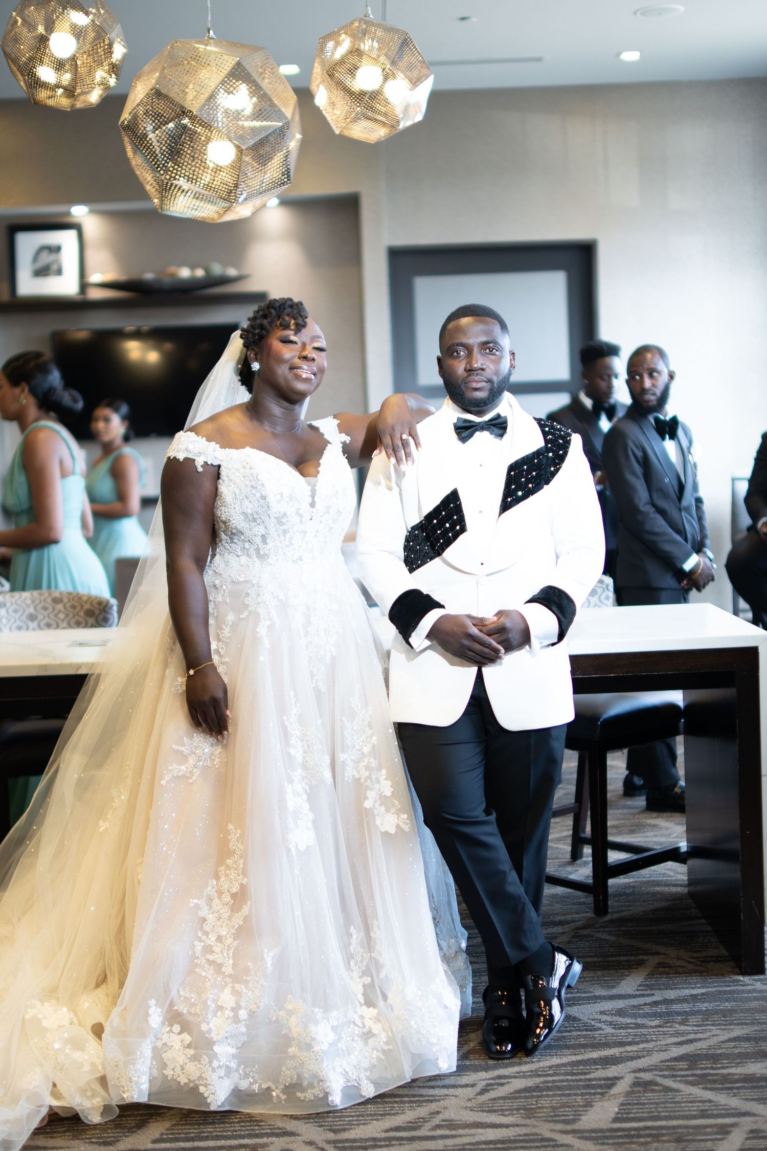 Wedding couple shares a joyful dance moment on their special day in an elegant indoor venue with modern lighting.