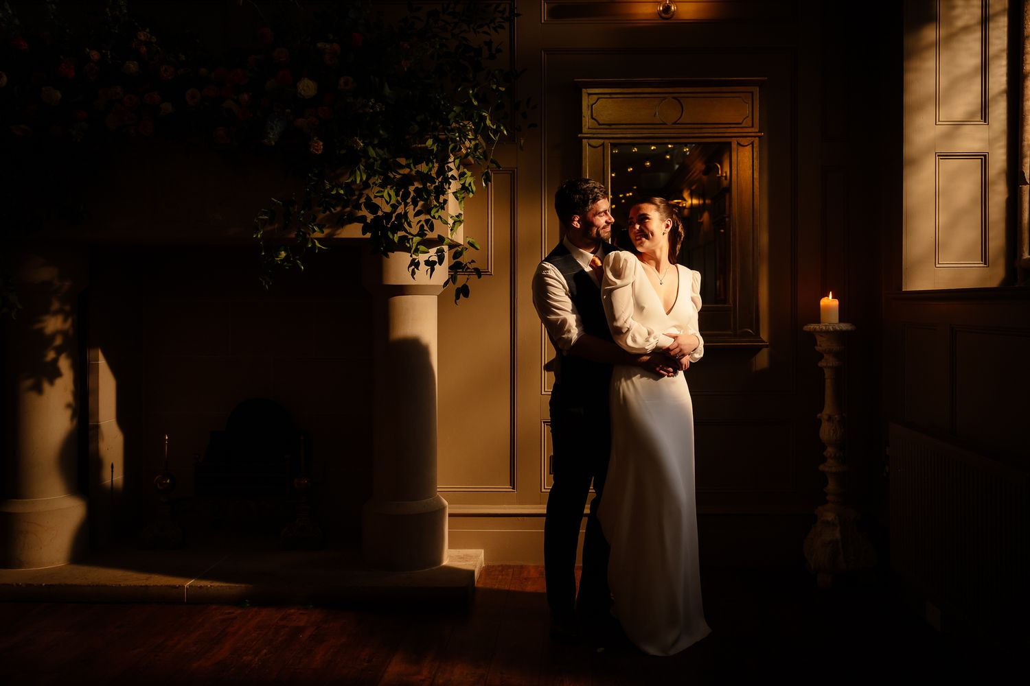 Candlelit wedding reception with guests mingling in an elegant venue. Ellingham Hall
