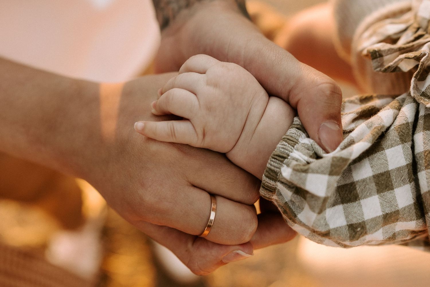 Close-up shots of hands exchanging wedding rings during an intimate ceremony with warm lighting.