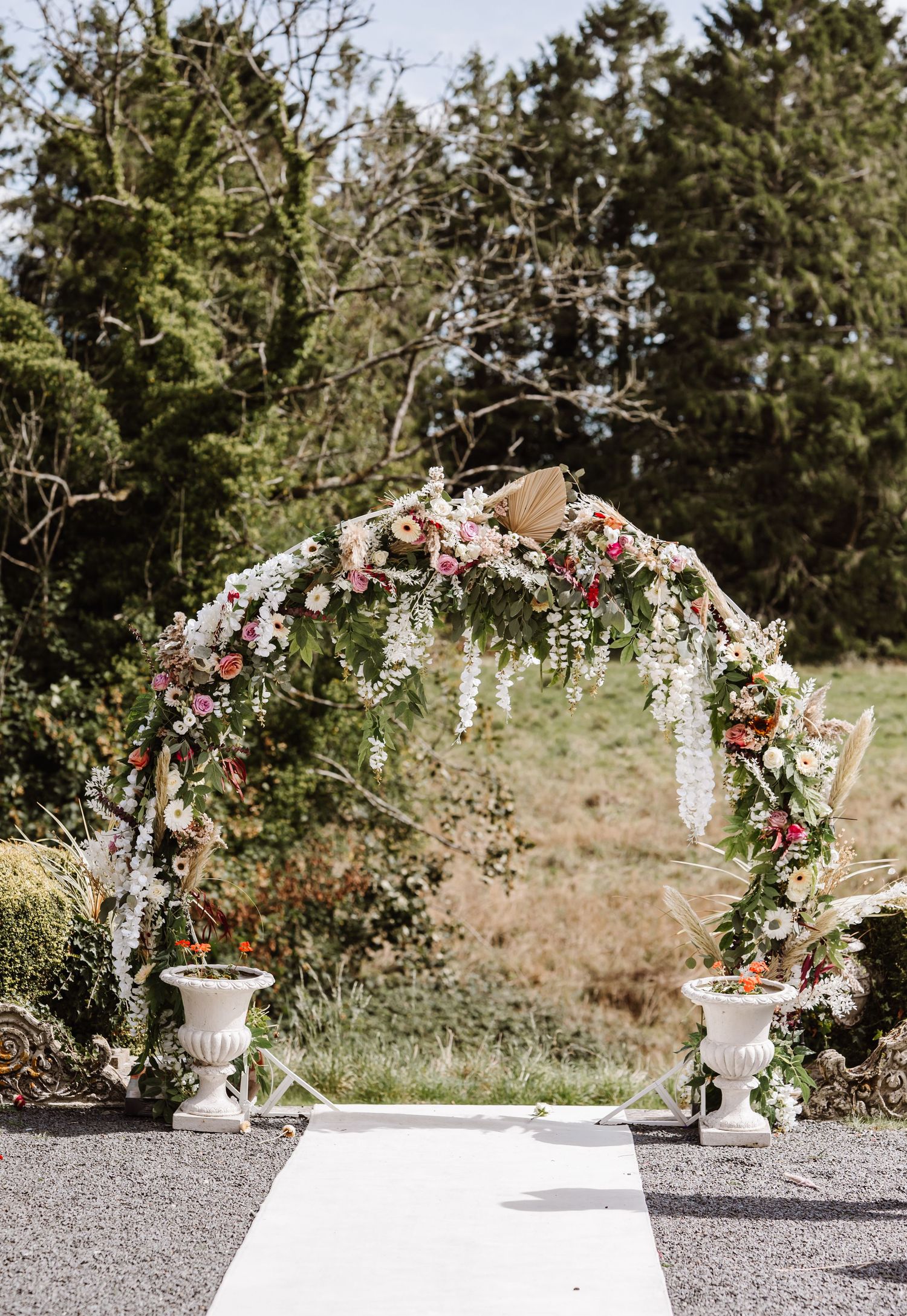 Dried floral archway at Holbrook Manor and Spa. Outdoor wedding. Candid Somerset Wedding Photographer.
