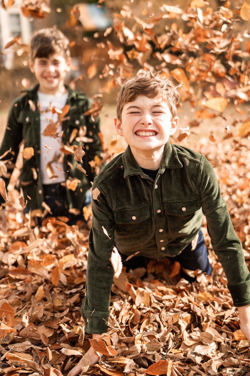 Having fun in the leaves during fall family portraits in Hinsdale, Illinois.