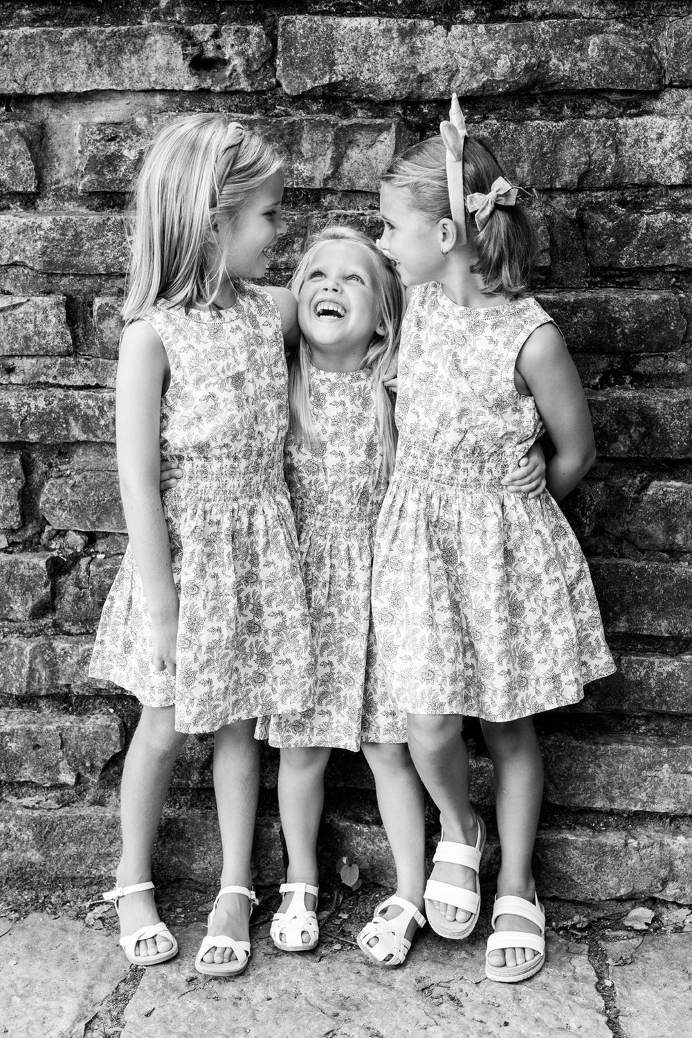Candid black and white photo of sisters during family session in Oak Brook, Illinois.