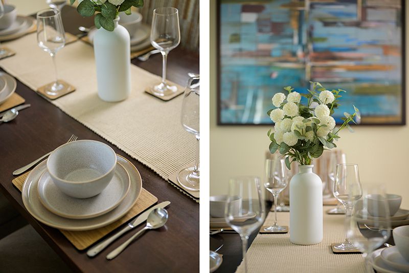 Elegant table settings with white flowers in vases, wine glasses, and place settings arranged for fine dining.