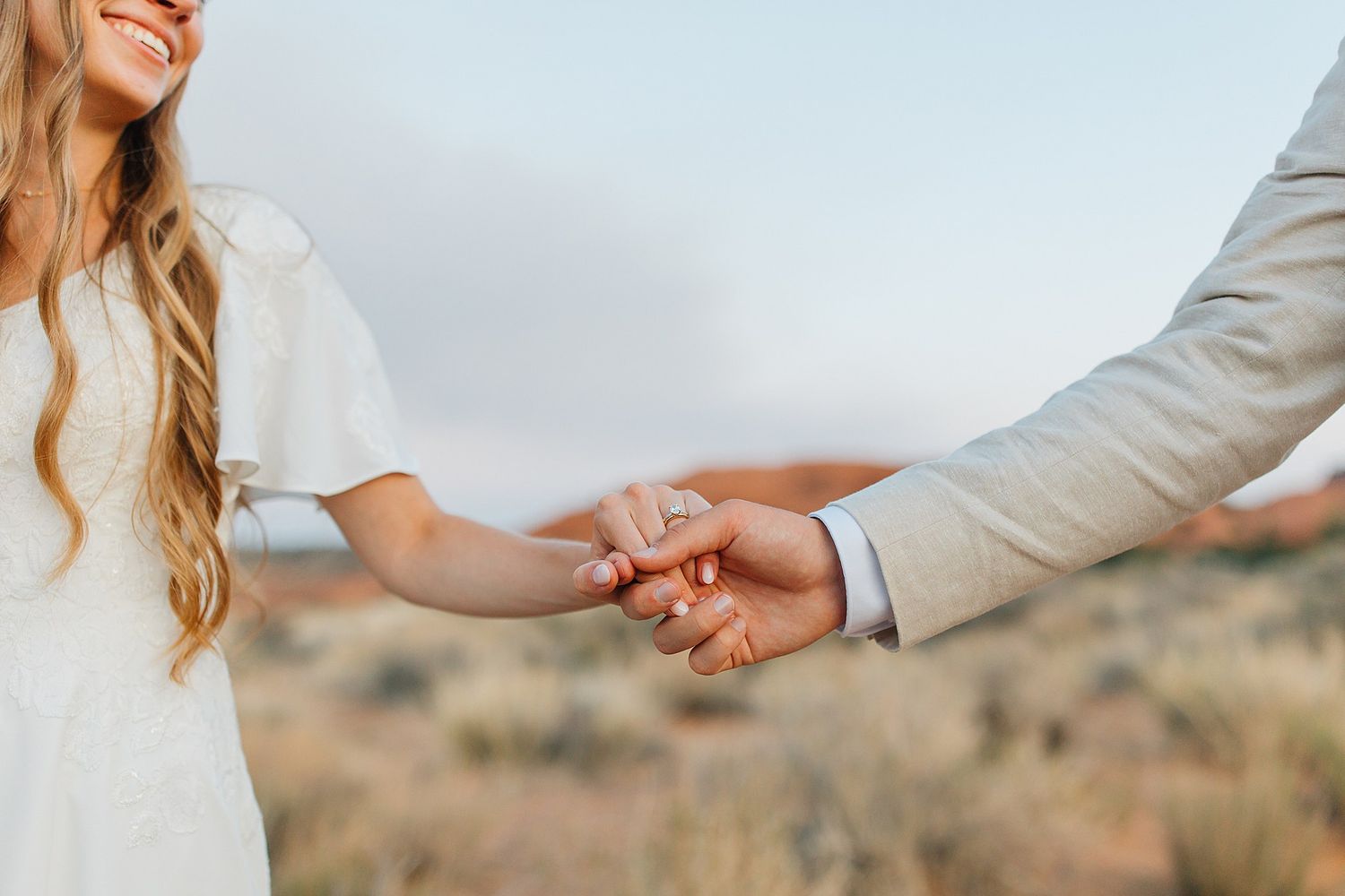 A series of romantic hand-holding photos between newlyweds in a desert landscape with warm lighting.