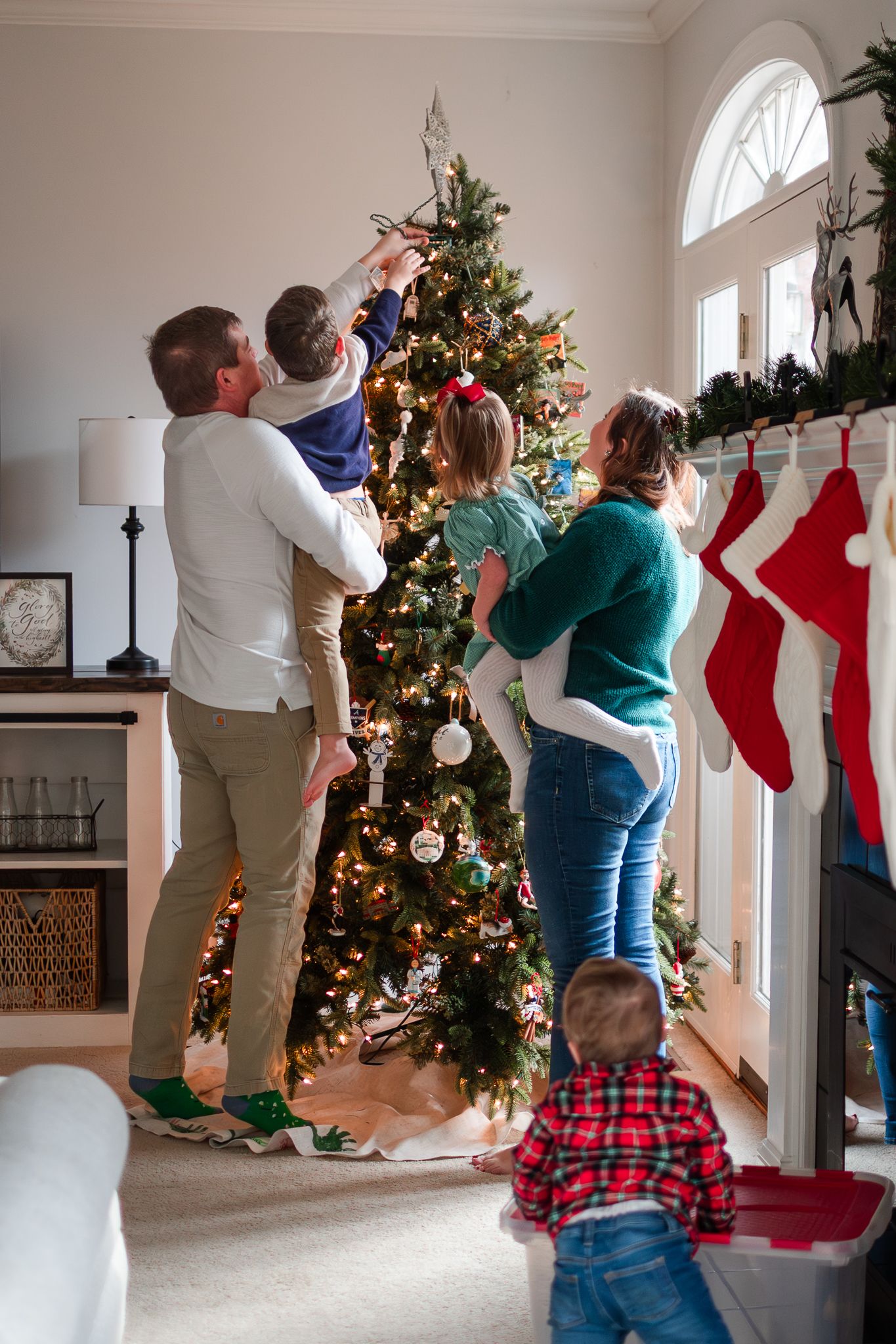 A series of playful holiday photos showing a couple lying on the floor in front of a decorated Christmas tree.