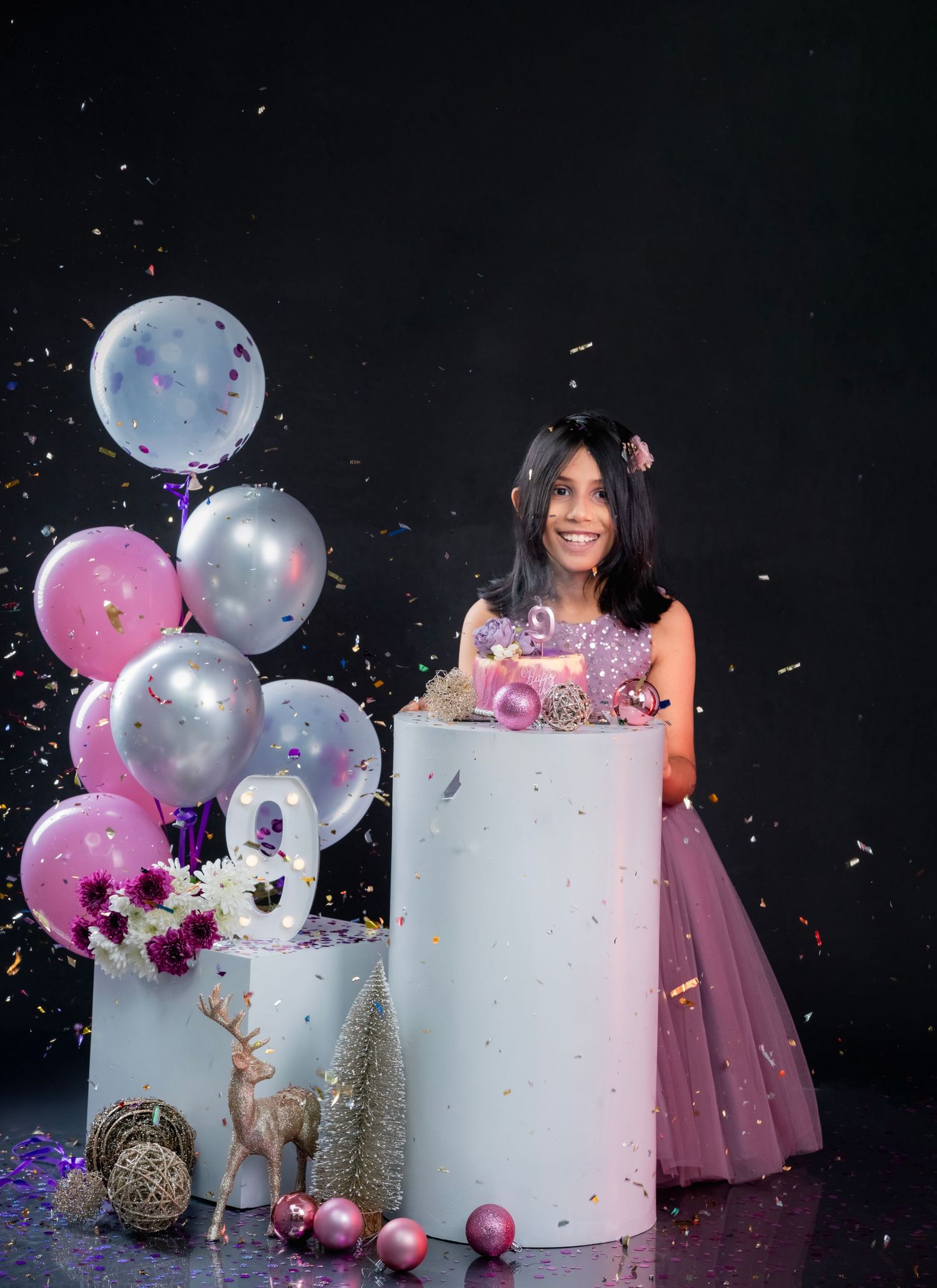 A gender reveal photo series with a large white cake and pink and silver balloons creating a magical celebratory scene.