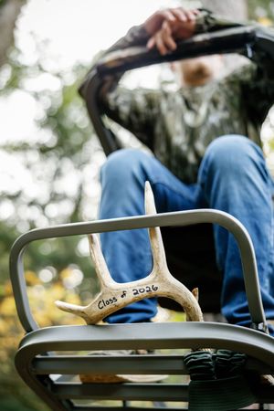 Close-up detail of deer antlers mounted on equipment against blurred outdoor background.