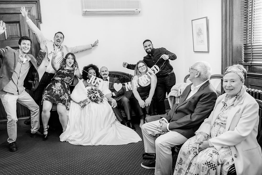 A series of black and white wedding photos showing candid moments of celebration and laughter at a reception.
