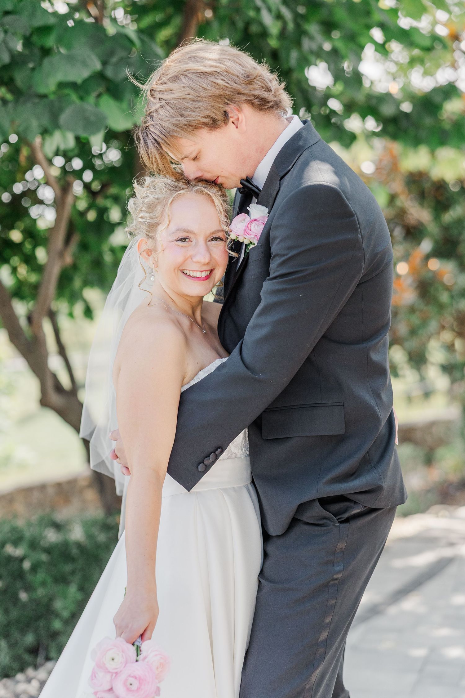 A joyful wedding moment captured in a garden setting with soft natural lighting.