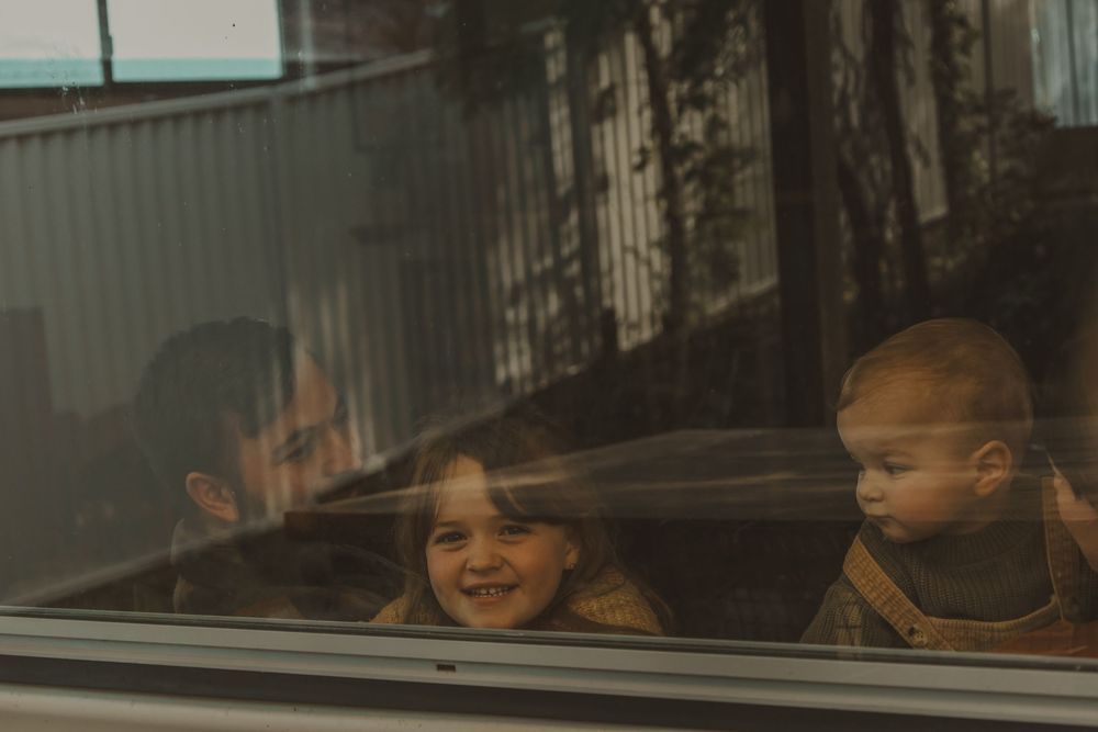 A series of seven photos showing children looking through windows with reflective expressions and lighting.