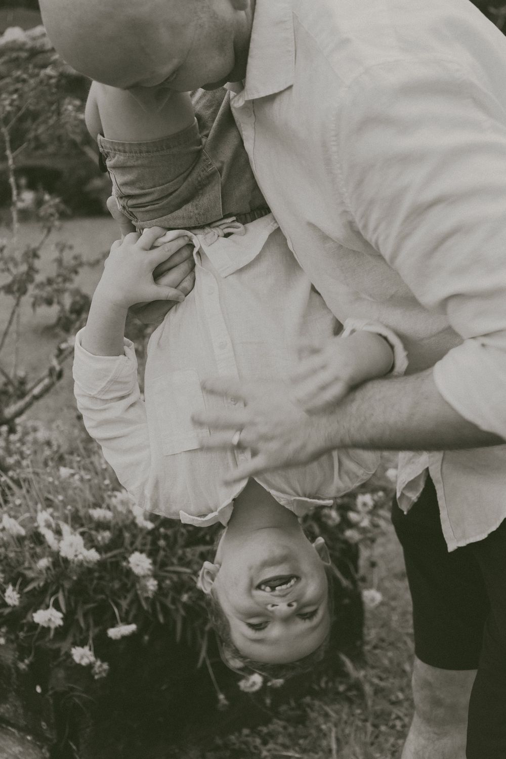 A black and white photo sequence shows someone bending forward and looking upside down at the camera with a playful expression.