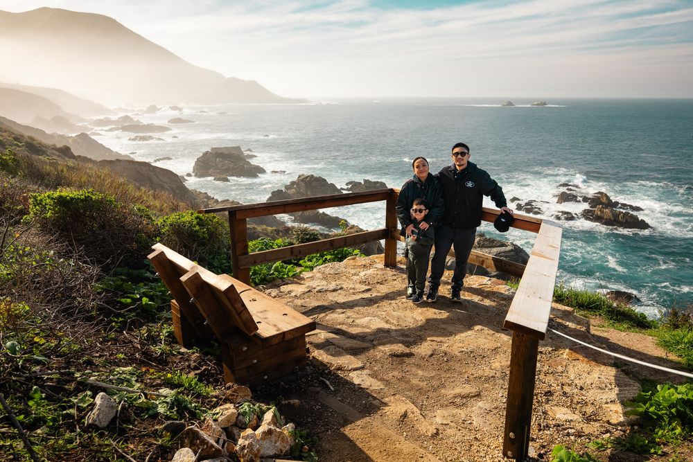 Scenic coastal viewpoint with rocky cliffs and crashing waves against the shoreline.