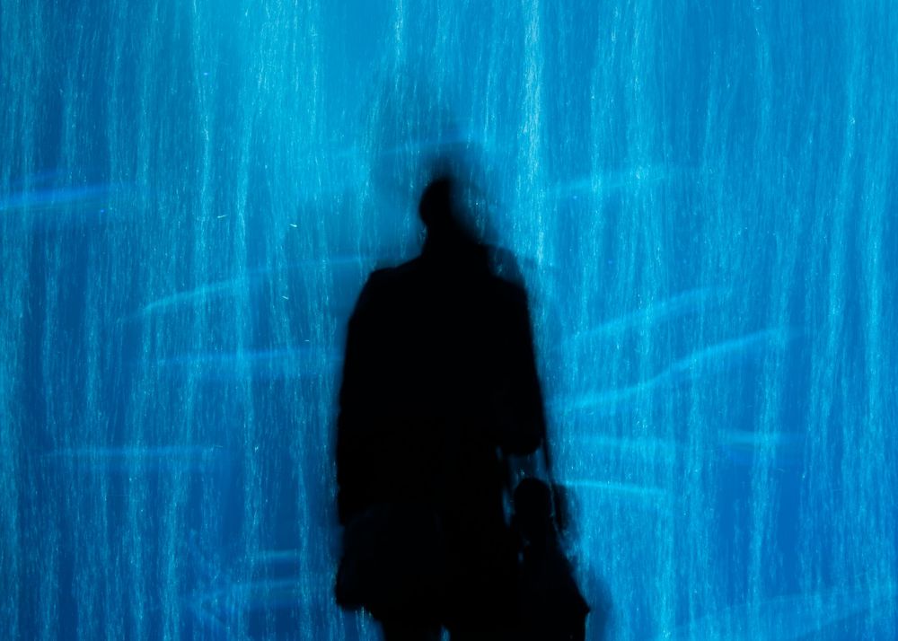Abstract blue light patterns creating vertical streaks against a dark background.