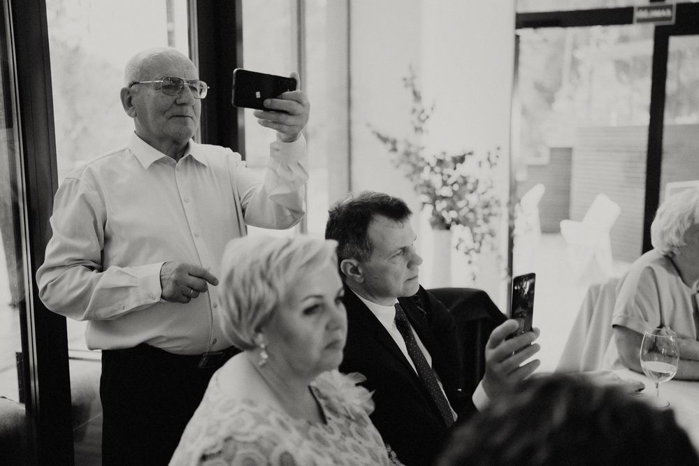 Black and white photo of guests taking pictures during a celebration event.