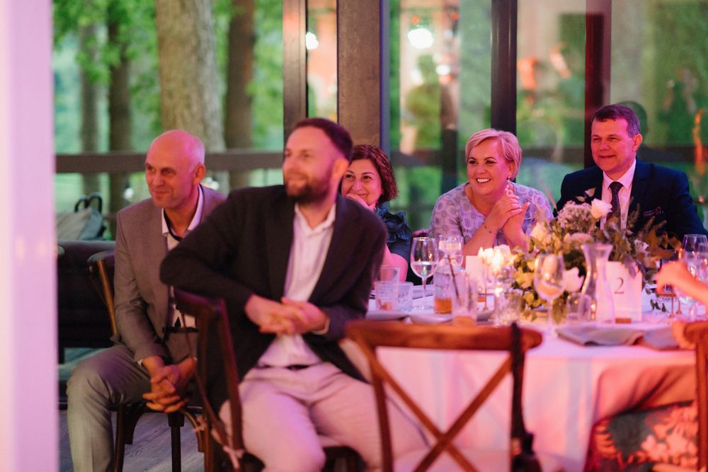 Wedding reception venue with long tables and pink ambient lighting creating a romantic atmosphere.