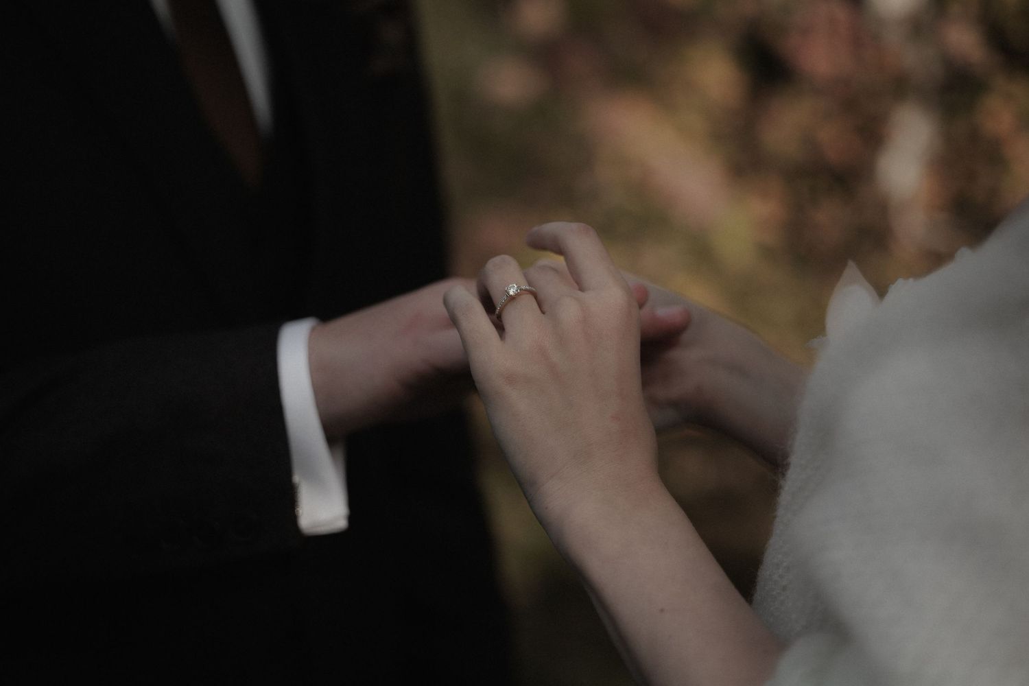Close-up shot of hands exchanging wedding rings during a romantic ceremony.