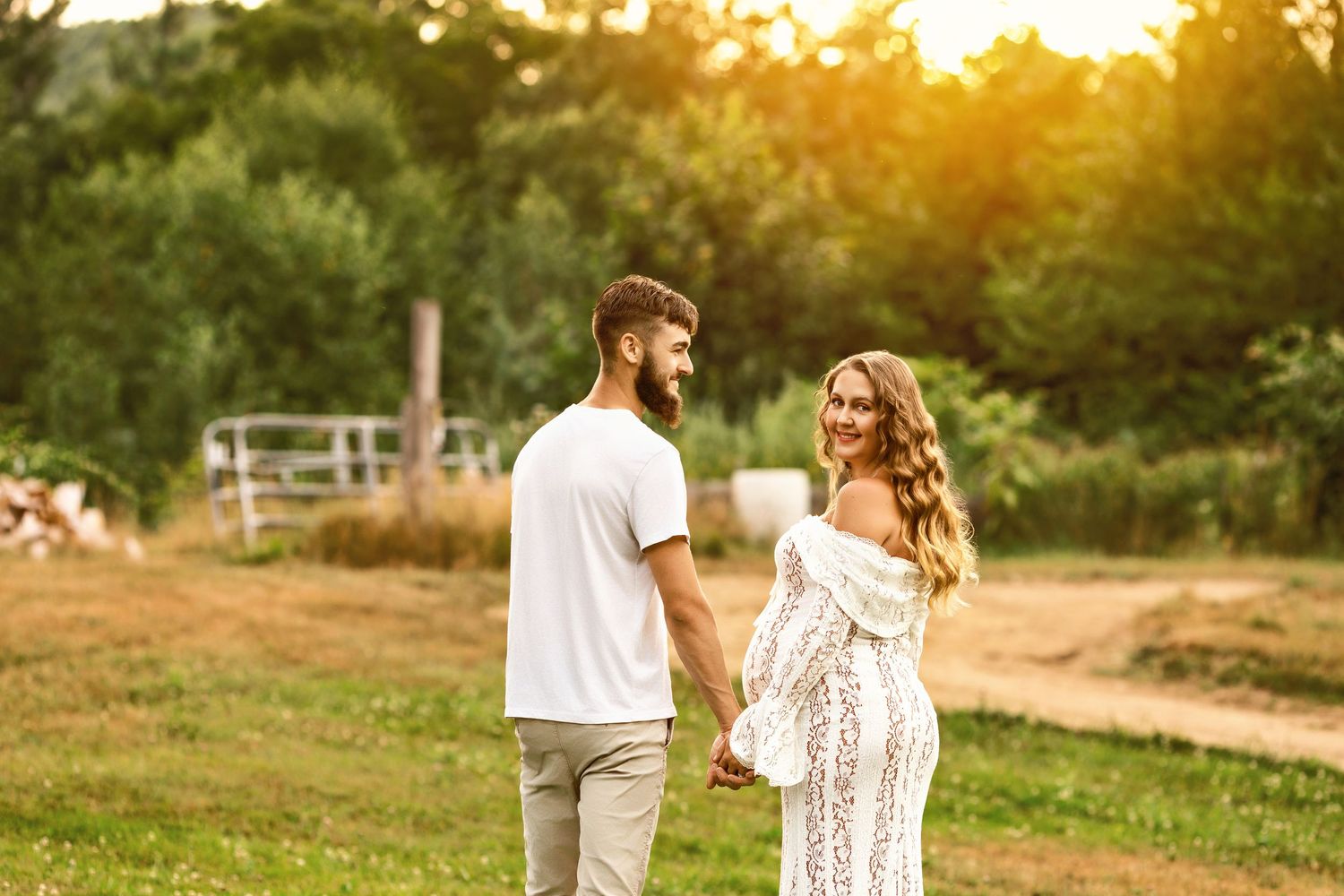 Concord NH maternity photography of an expecting couple holding hands, outdoor pregnancy portrait with natural light and connection.