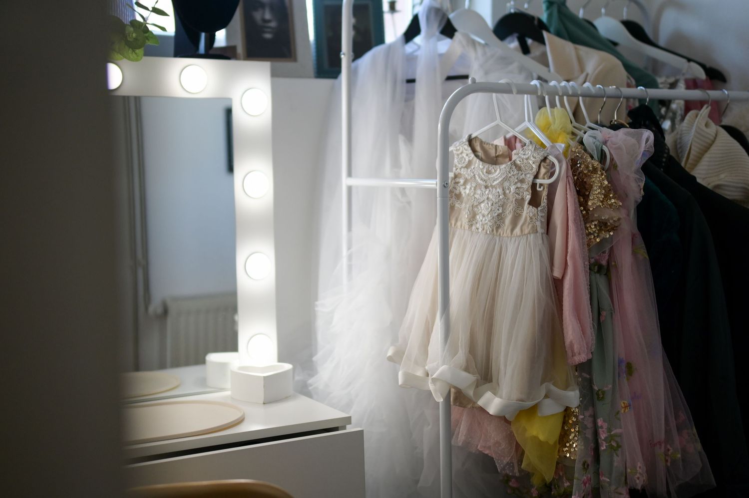Ethereal white tulle drapes create a dreamy atmosphere in a teal-colored room with romantic floral arrangements.