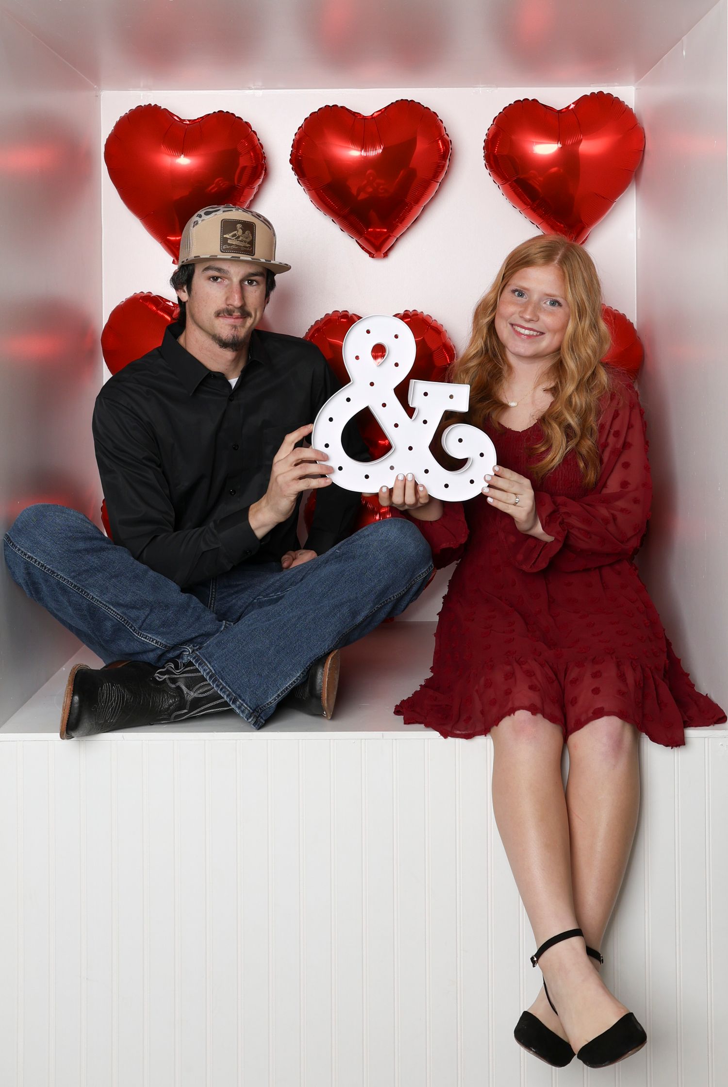 Valentine's themed couple photo with heart decorations and an ampersand symbol. Box photography session