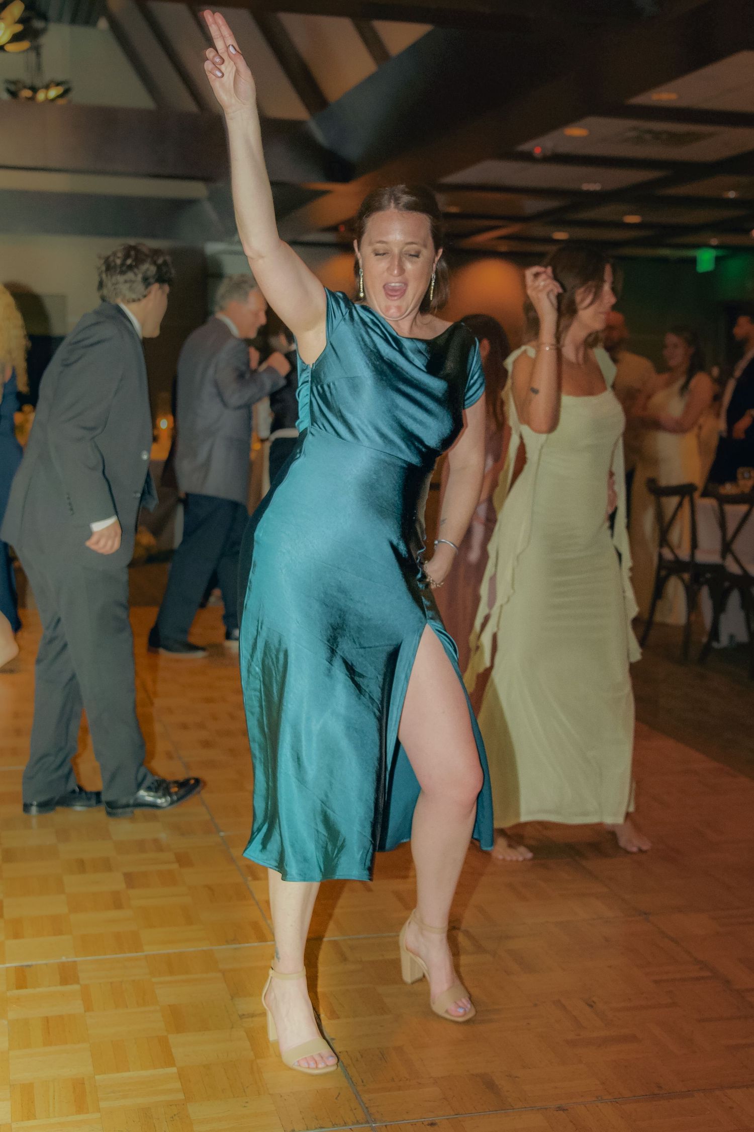 People dancing barefoot on a wooden dance floor during a social dance event in casual attire.