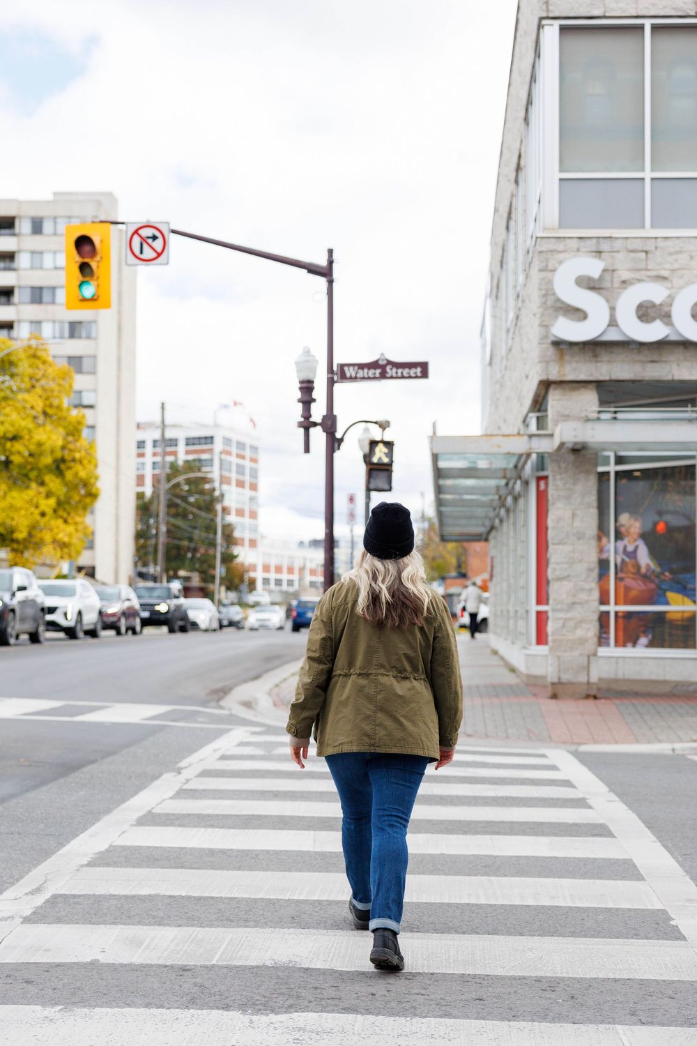 A sequence of photos showing someone walking across a crosswalk on a quiet urban street.
