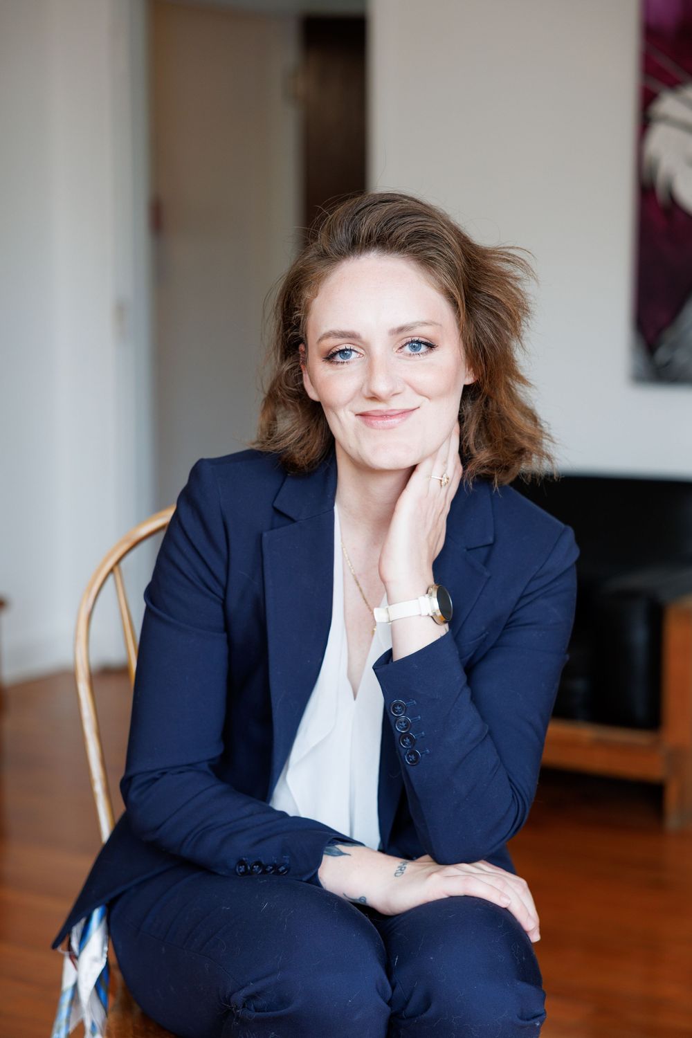 Professional in navy blazer and white shirt poses casually in sequence of five relaxed business portraits.