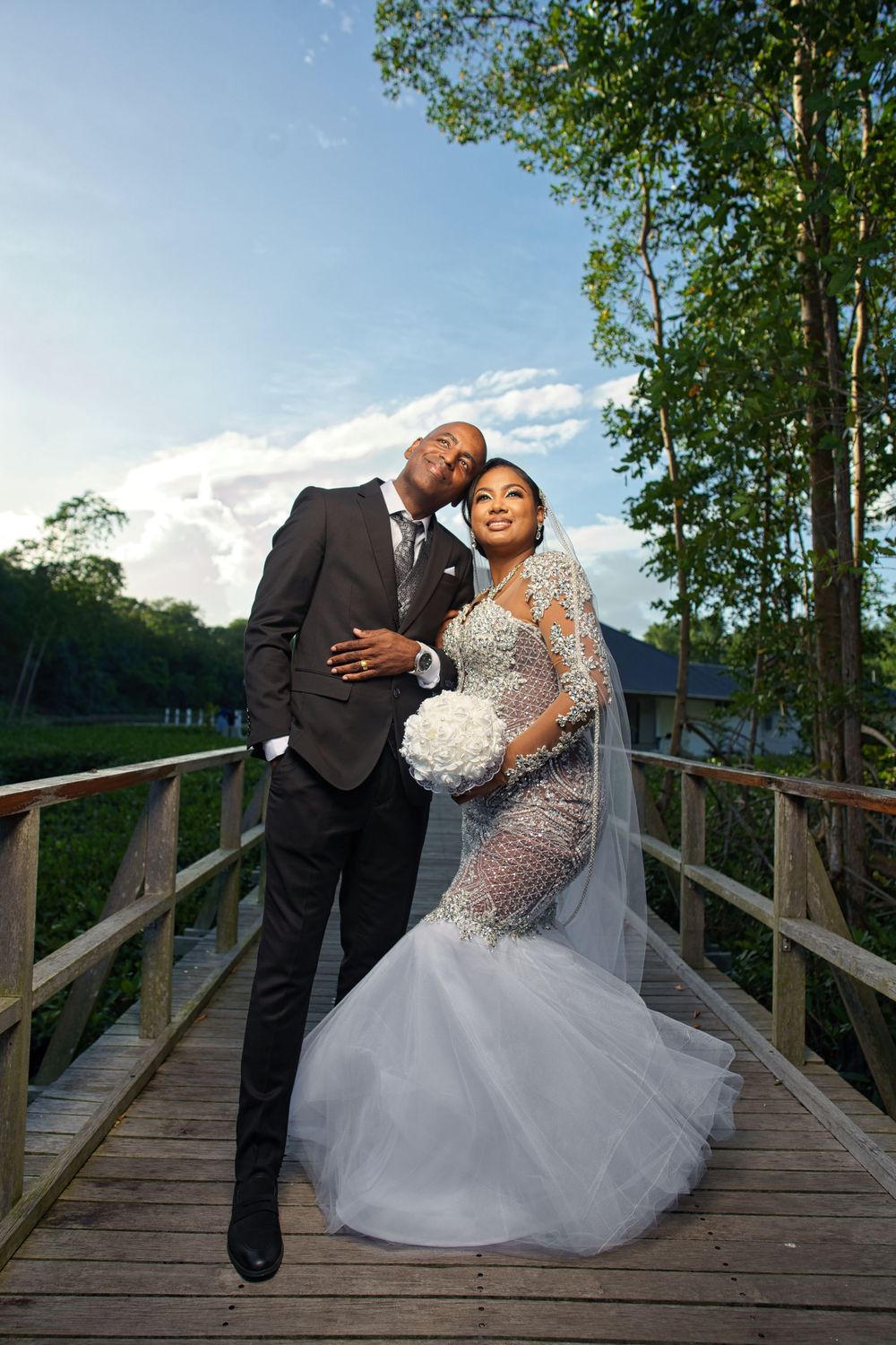 A romantic wedding photoshoot sequence on a wooden bridge surrounded by lush greenery on a sunny day.