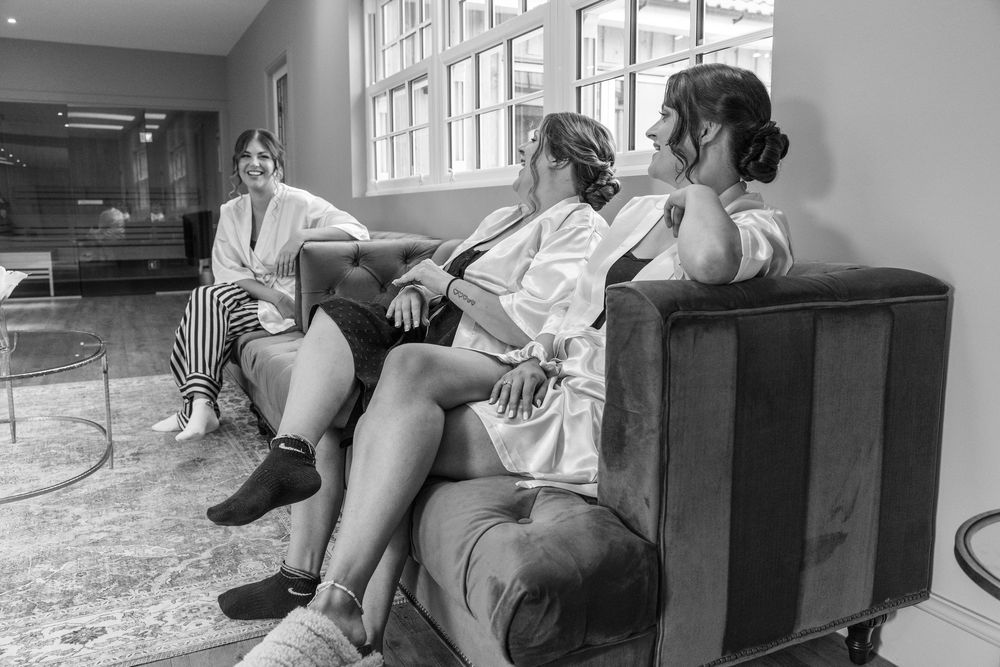 Black and white photo of wedding party members relaxing in robes before ceremony.