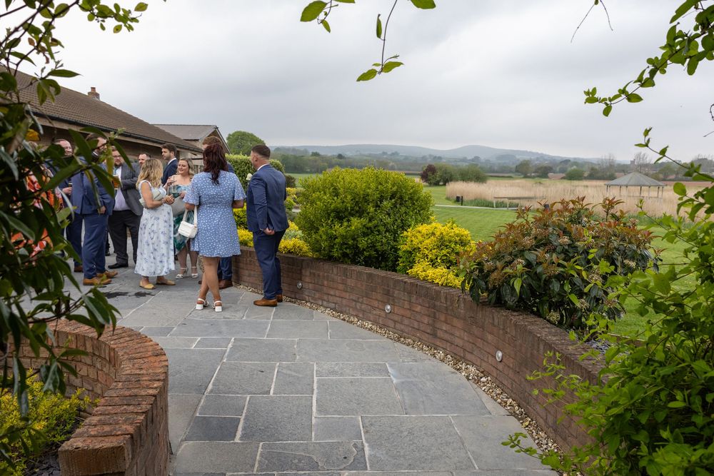 Stone patio overlooking scenic countryside with brick walls and greenery.