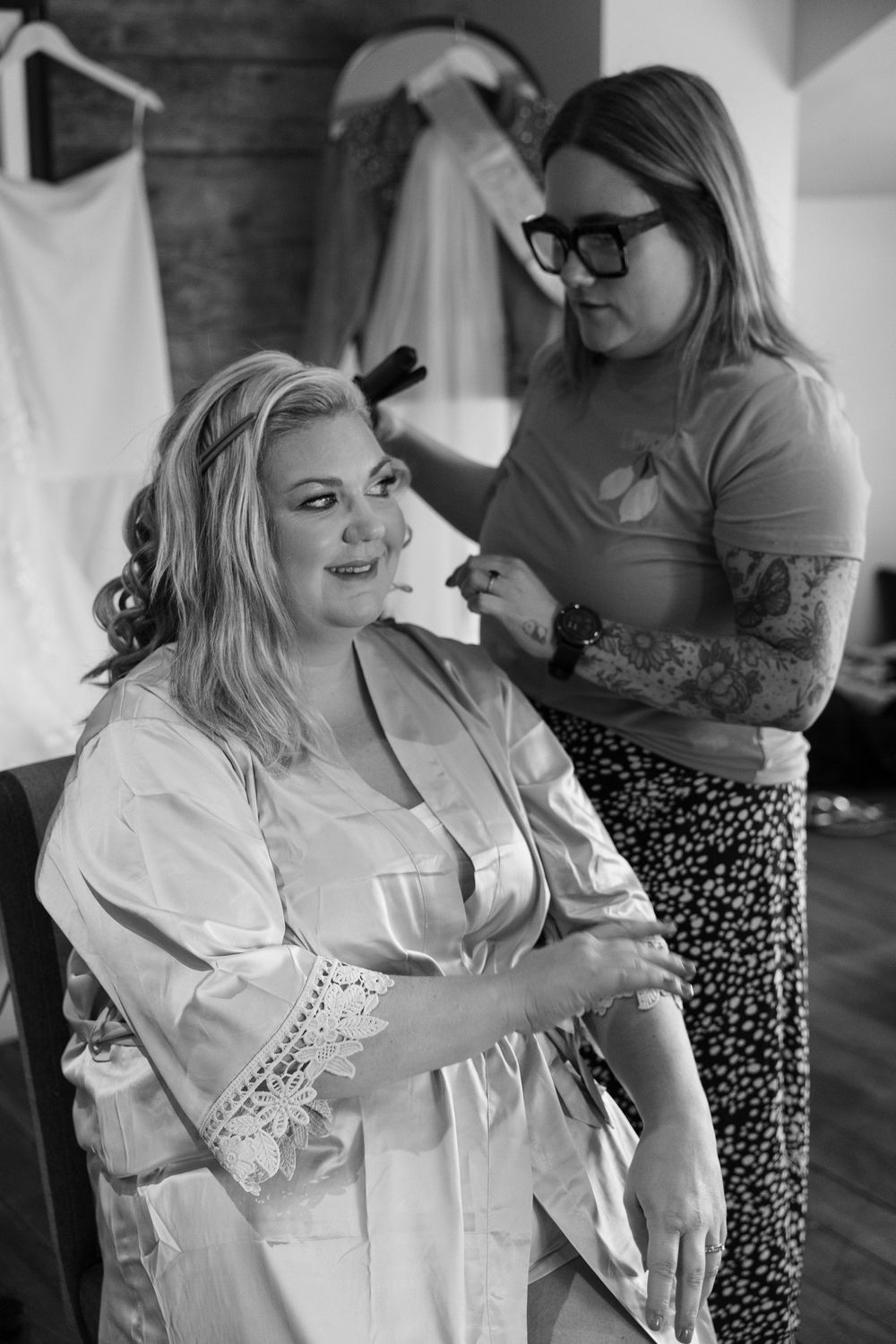 Black and white photos show a woman in a white robe getting ready in a rustic room with wooden floors.