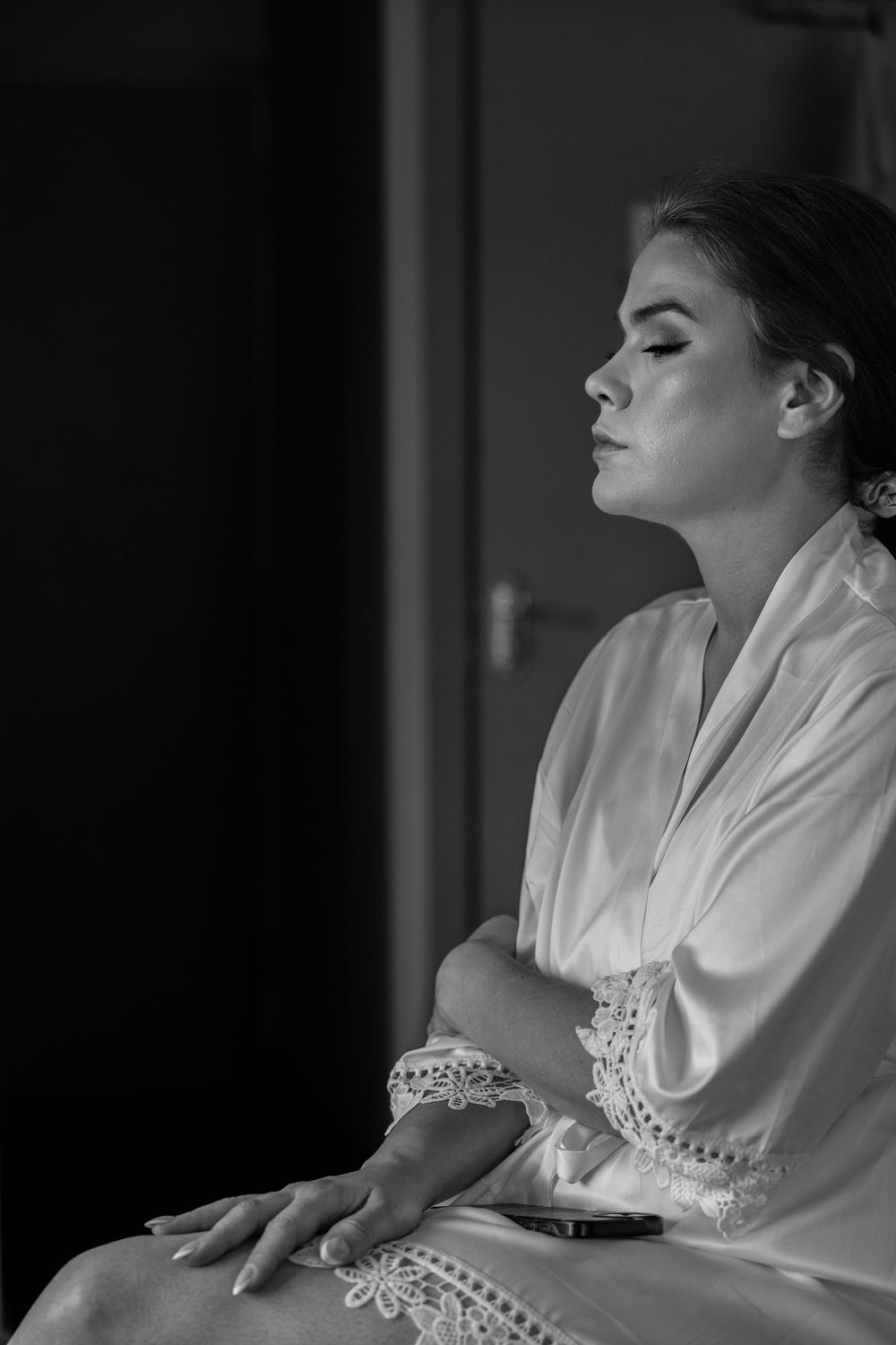 A series of black and white photos showing someone in an elegant white robe with lace trim posing dramatically.