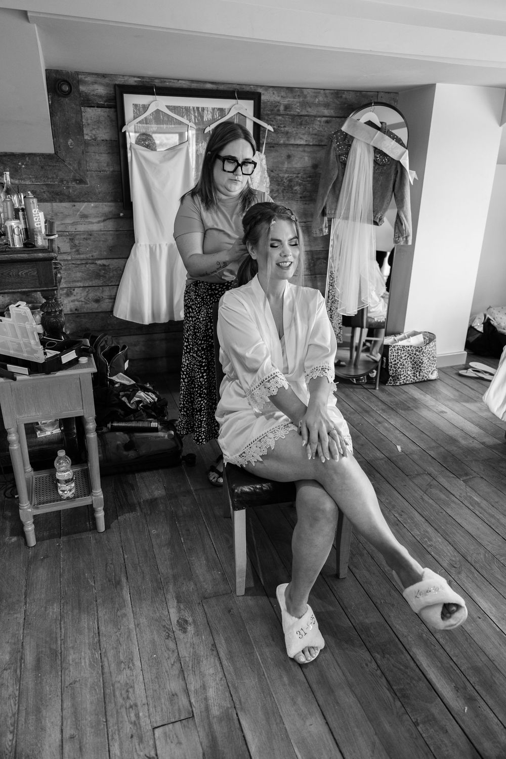 A series of candid getting-ready moments captured in black and white on a wooden floor.
