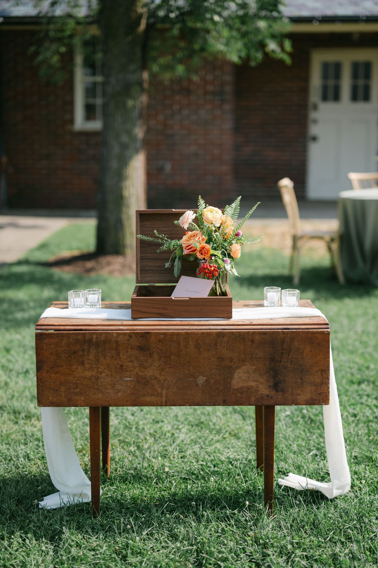 Rustic wooden benches with floral arrangements set up on grass for an outdoor wedding ceremony. - Elawa Farm