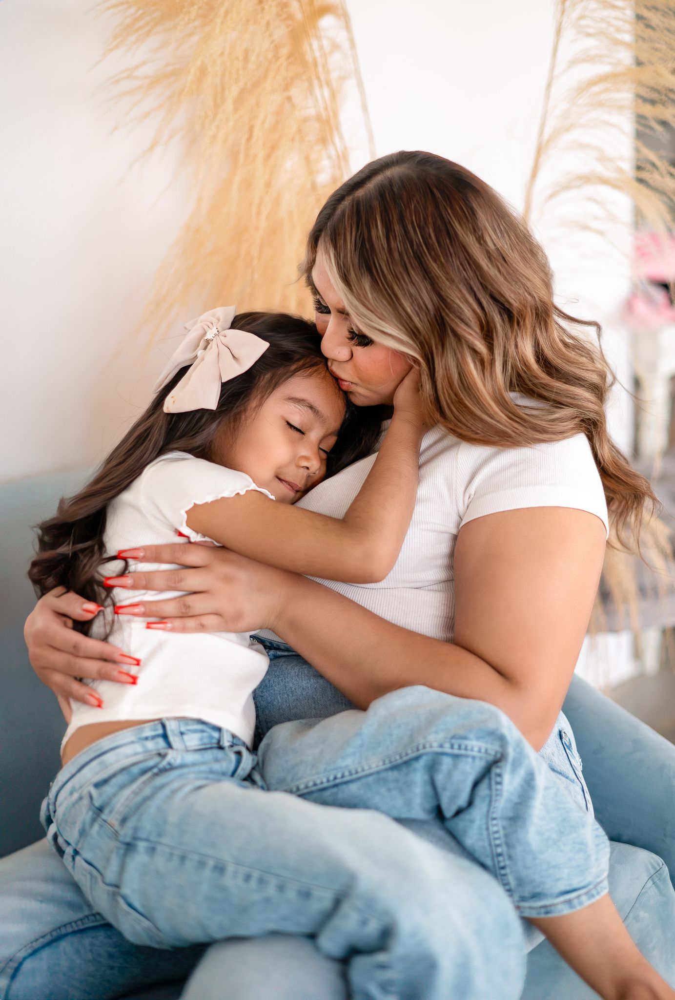 A mother kissing her daughter's forehead at StudioOne, Colorado.
