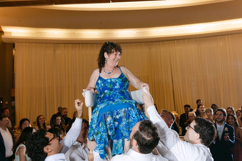 Guests enjoying themselves at a lively wedding reception with decorative lighting.