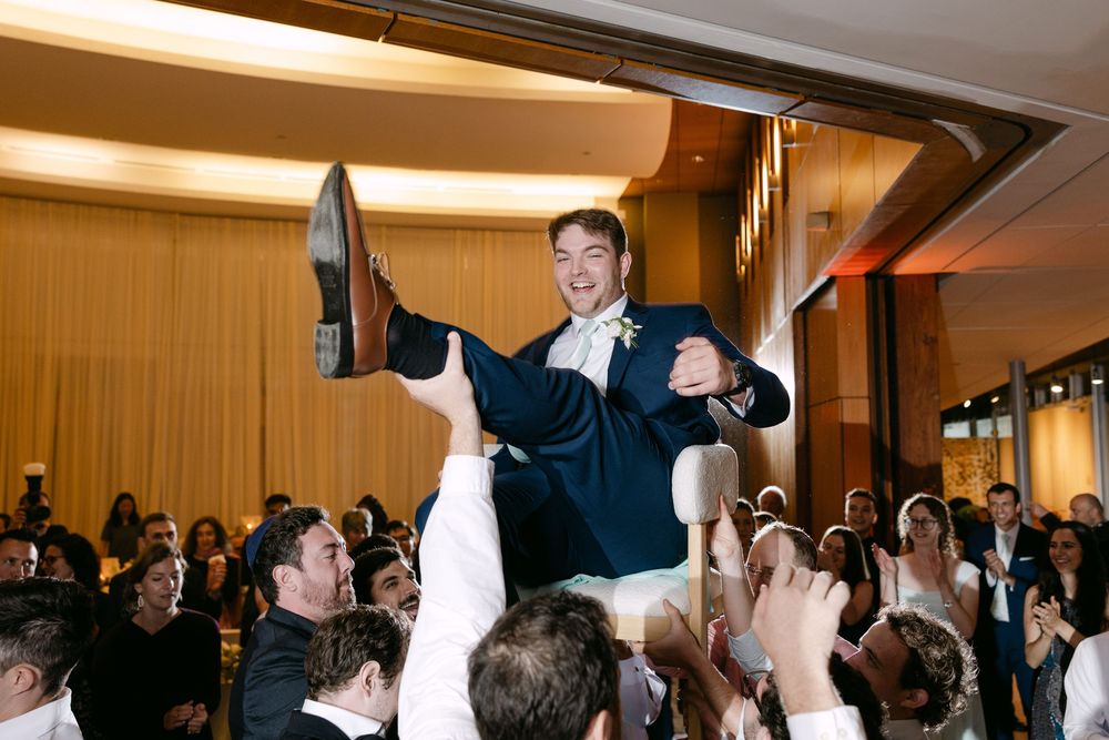 Guests gather around the dance floor to watch energetic wedding reception dancing and entertainment.