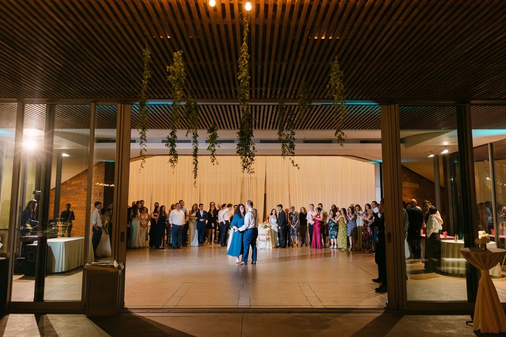 Panoramic view of an elegant wedding reception hall with modern architectural details and warm lighting.